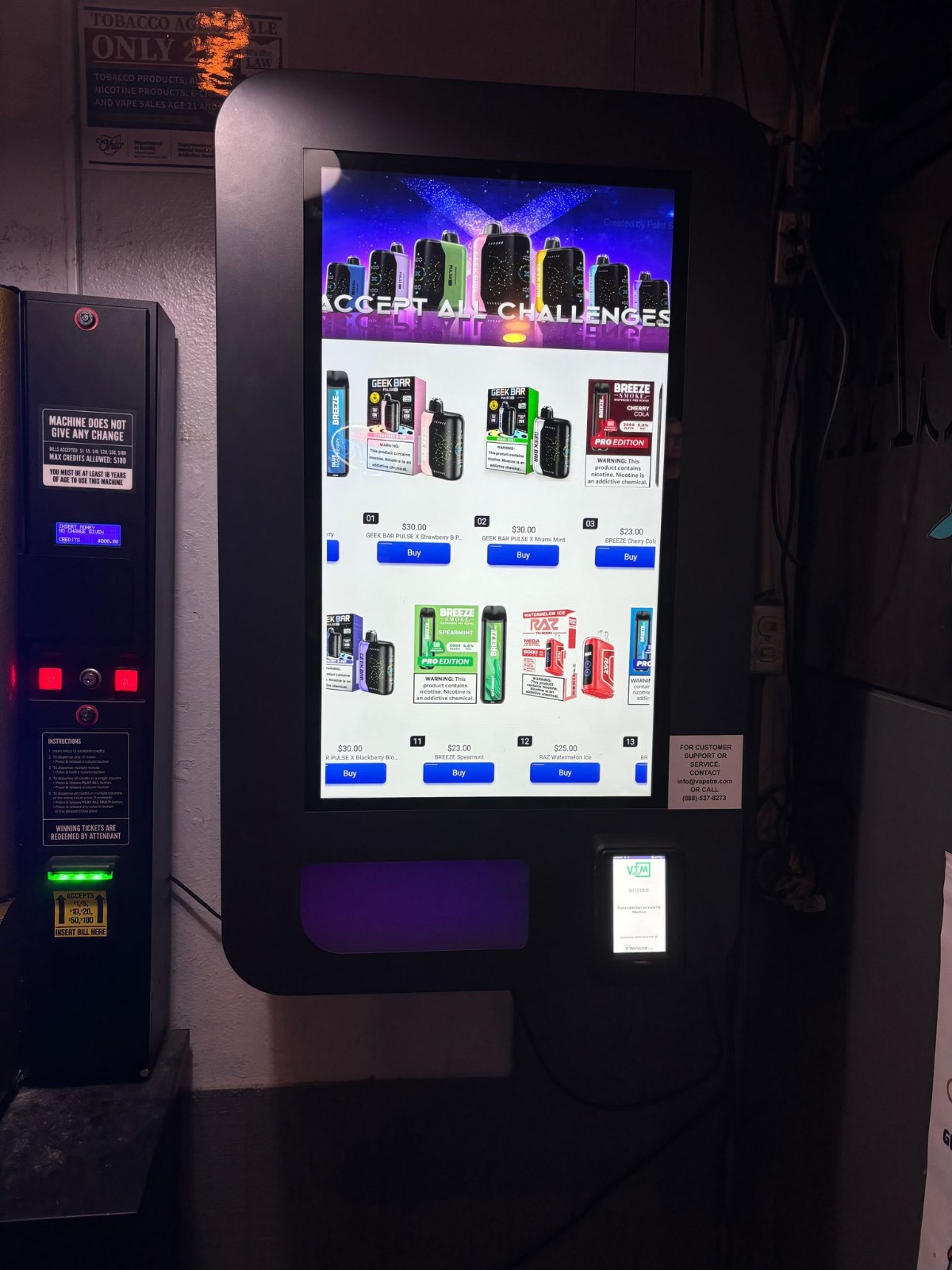 Wall-mounted nightlife vending machine with a glowing touchscreen inside a bar