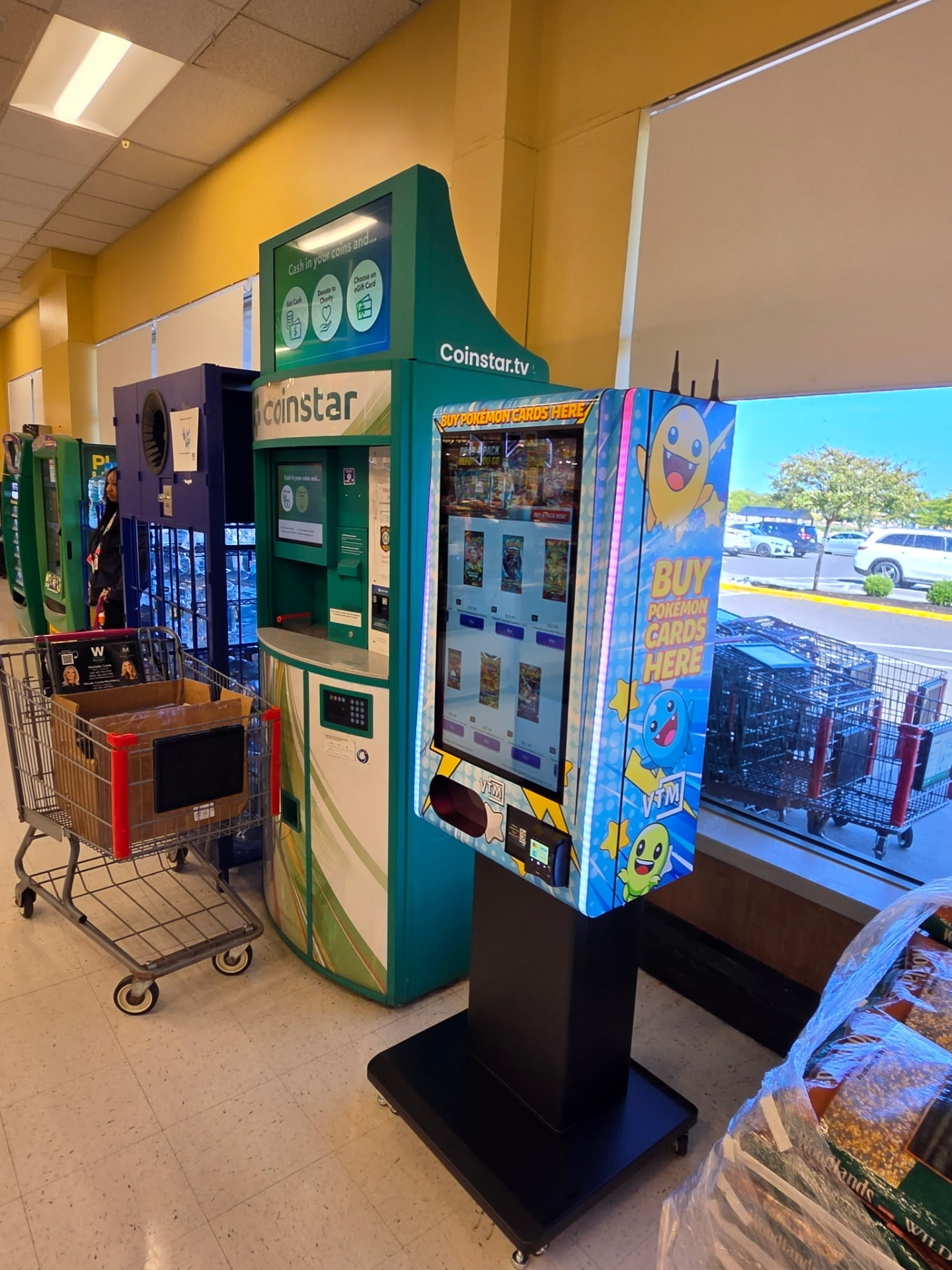 Pokémon card vending machine beside a Coinstar kiosk at a grocery store entrance